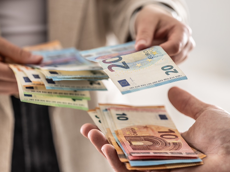 Abbildung der Hände zweier Personen, die Bargeld austauschen